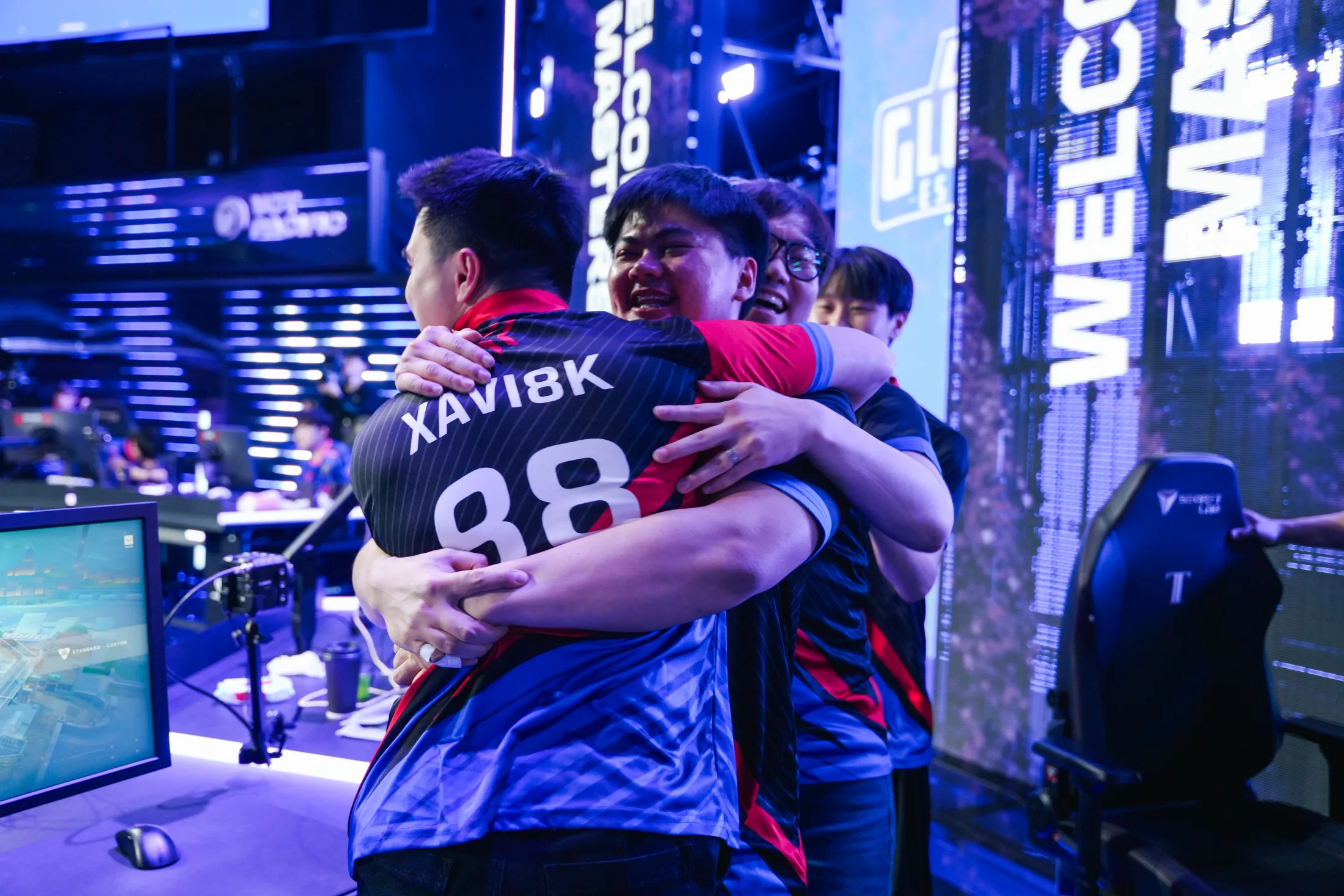 Global Esports players embrace on stage after a win